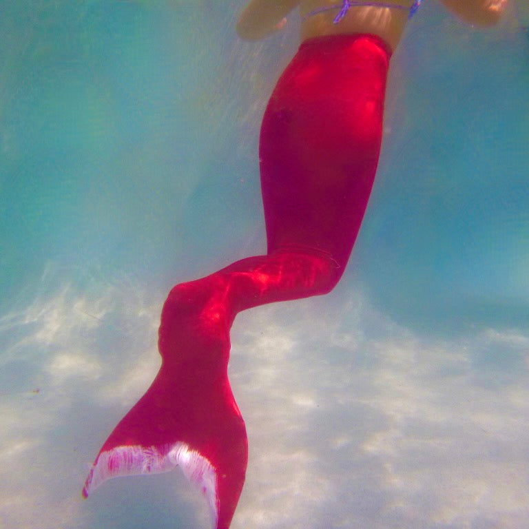 Girl wearing red swimmable mermaid tail Brisbane Australia