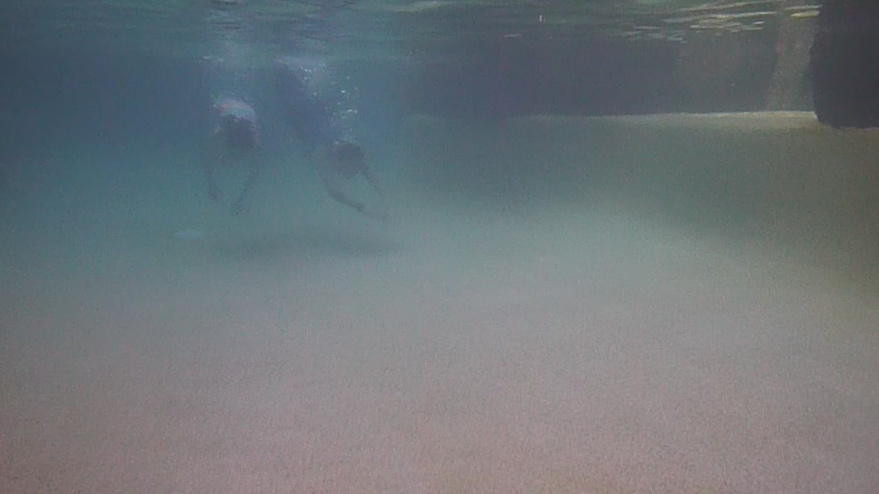 Two girls swimming wearing swimmable mermaid tails with a monofin in the bottom Brisbane Australia