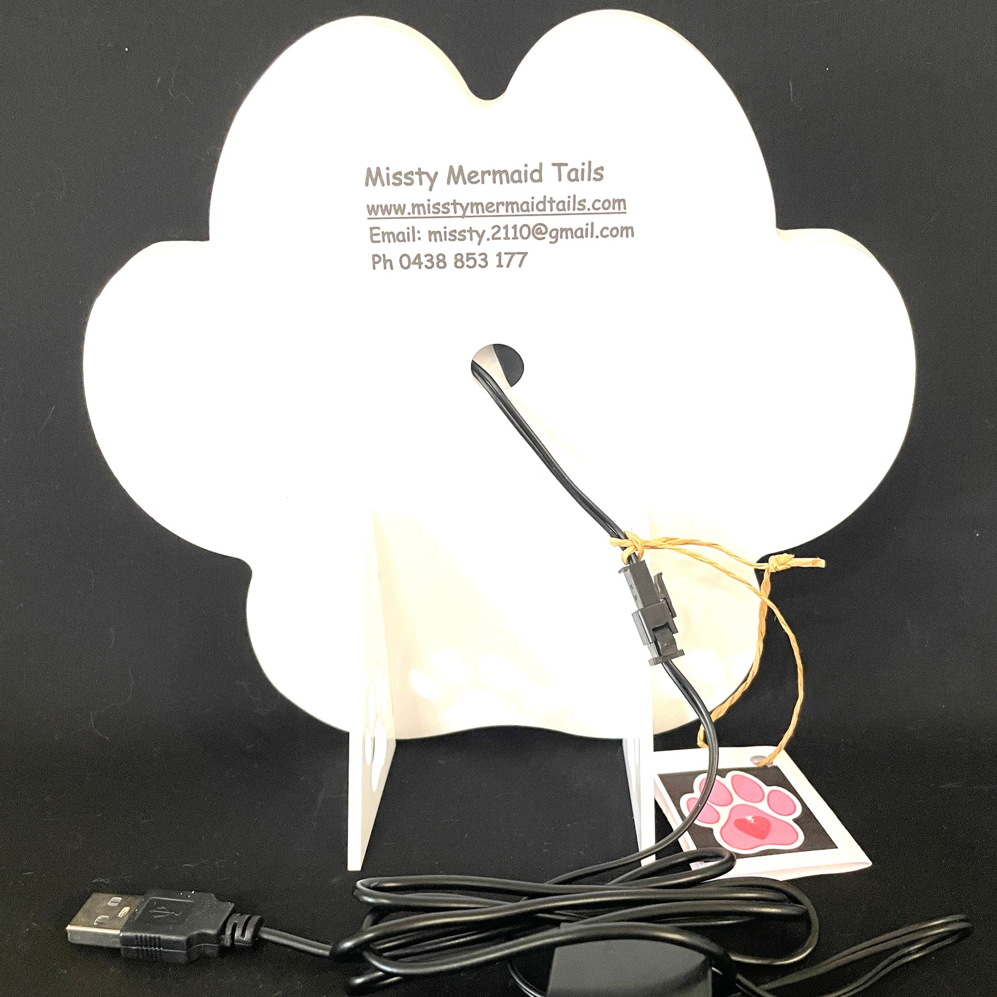 Back view of paw print neon light with a USB lead