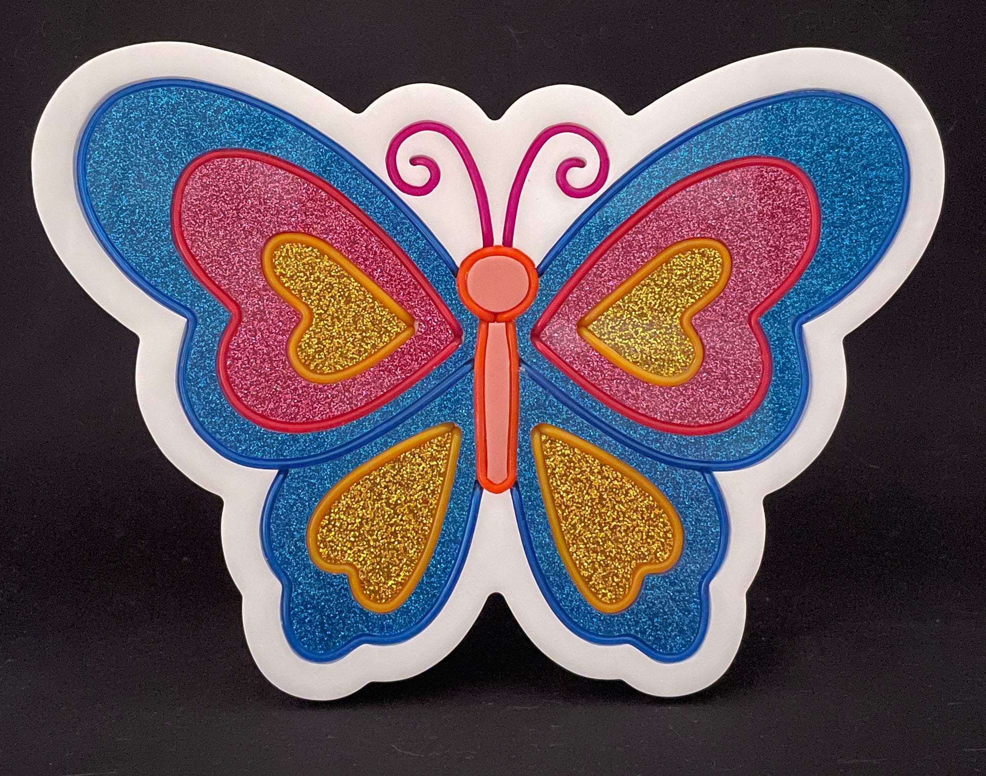 Blue, pink and gold butterfly with its wings open neon light not lit up