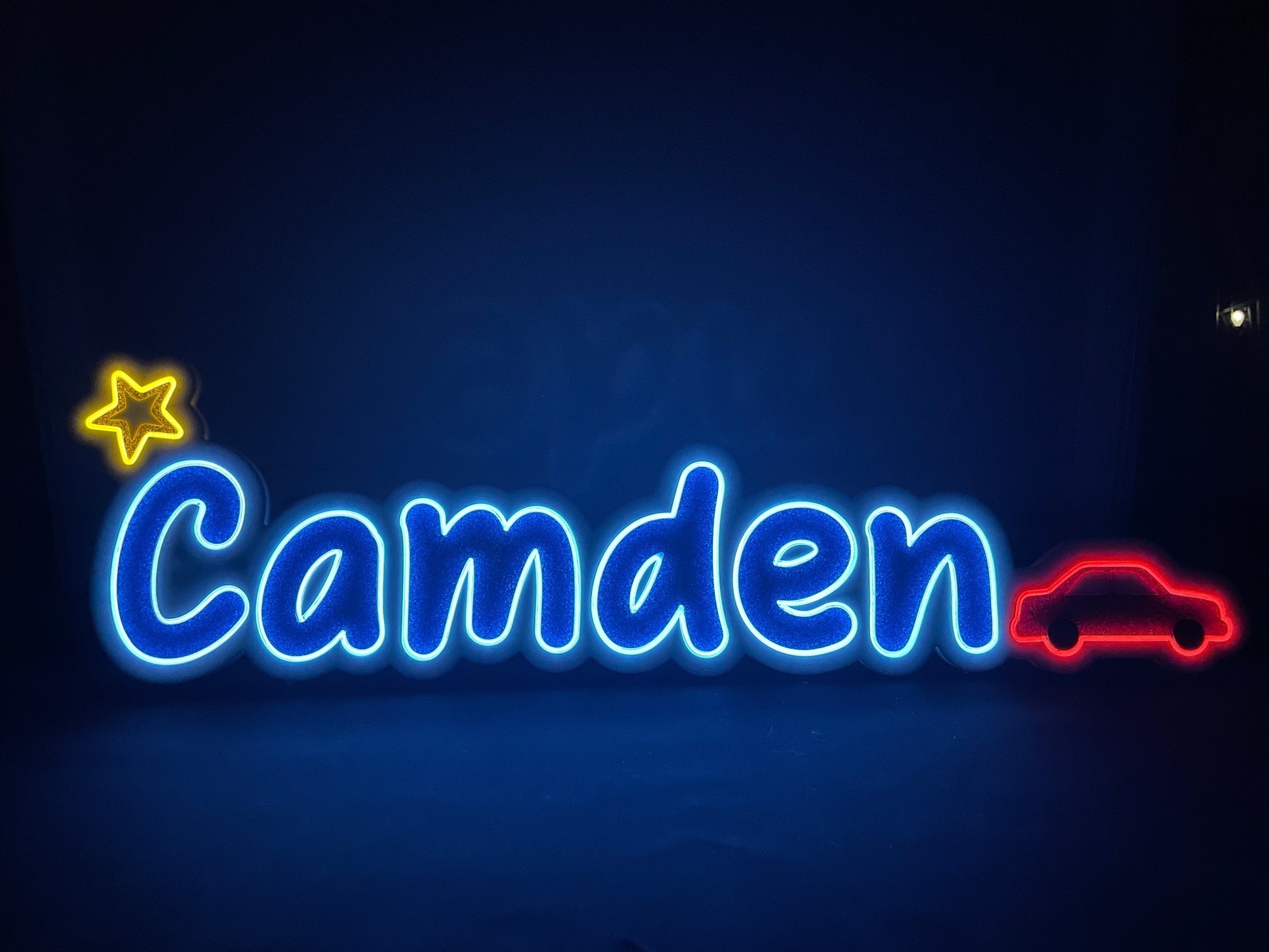 Camden neon name light in blue with a Star at the beginning and a red car at the end displayed let up