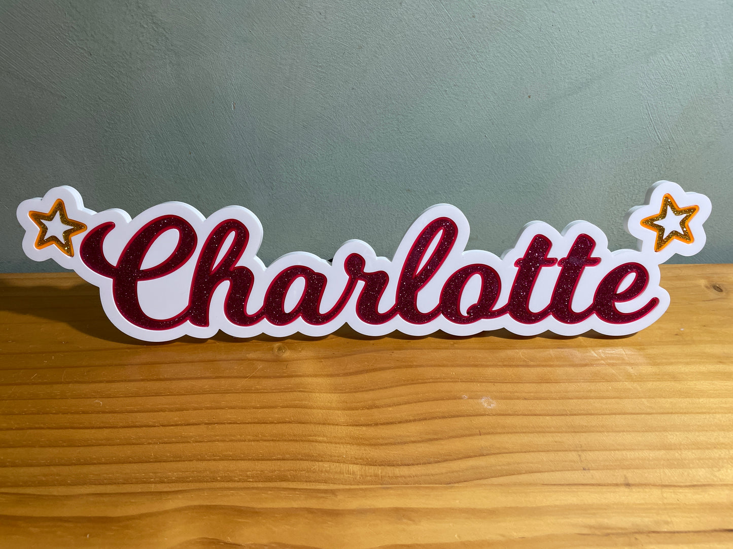 Charlotte neon name light in pink with a star at each end displayed during the day 