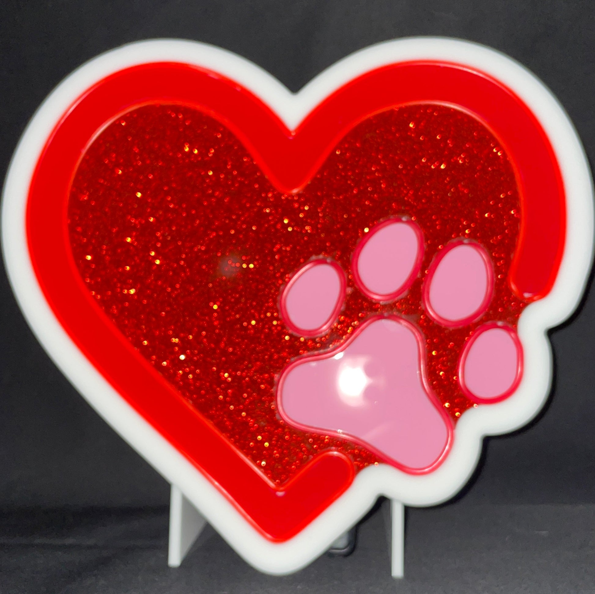 Red heart with a pink paw print neon light displayed not lit up