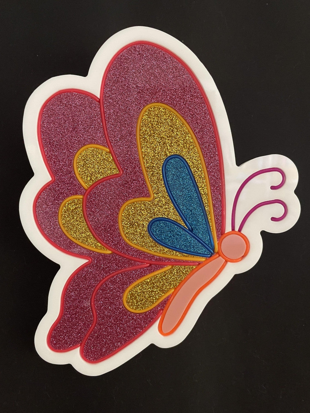 Pink, gold and blue butterfly with its wings closed  neon light not lit up