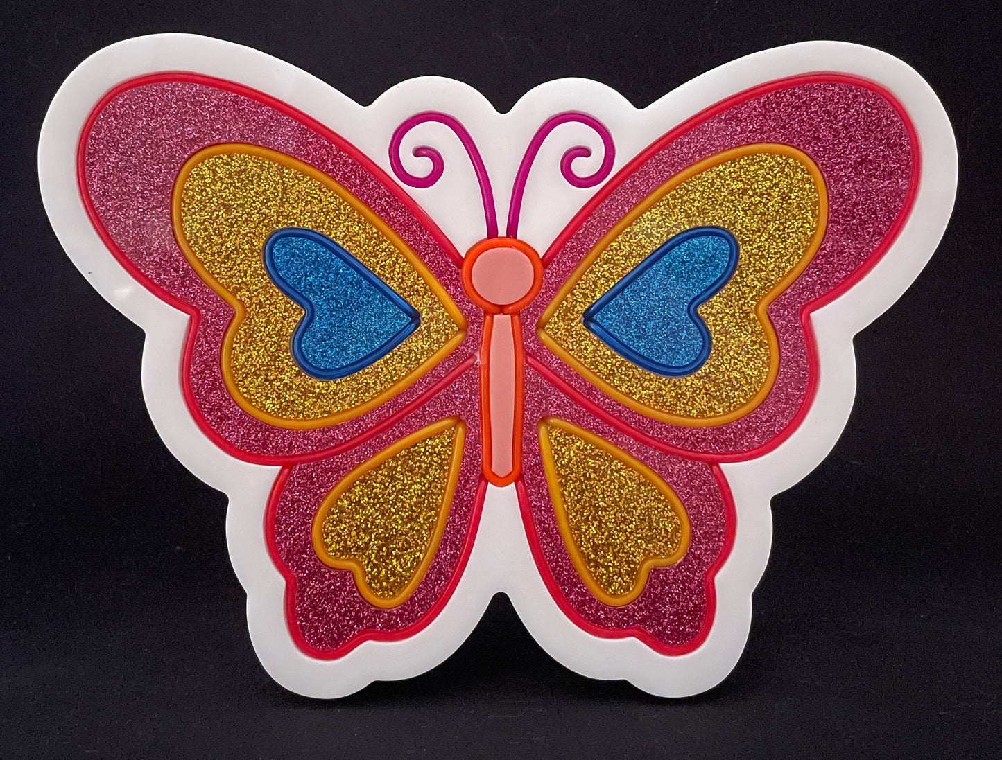 Pink, gold and blue butterfly with its wings open neon light not lit up