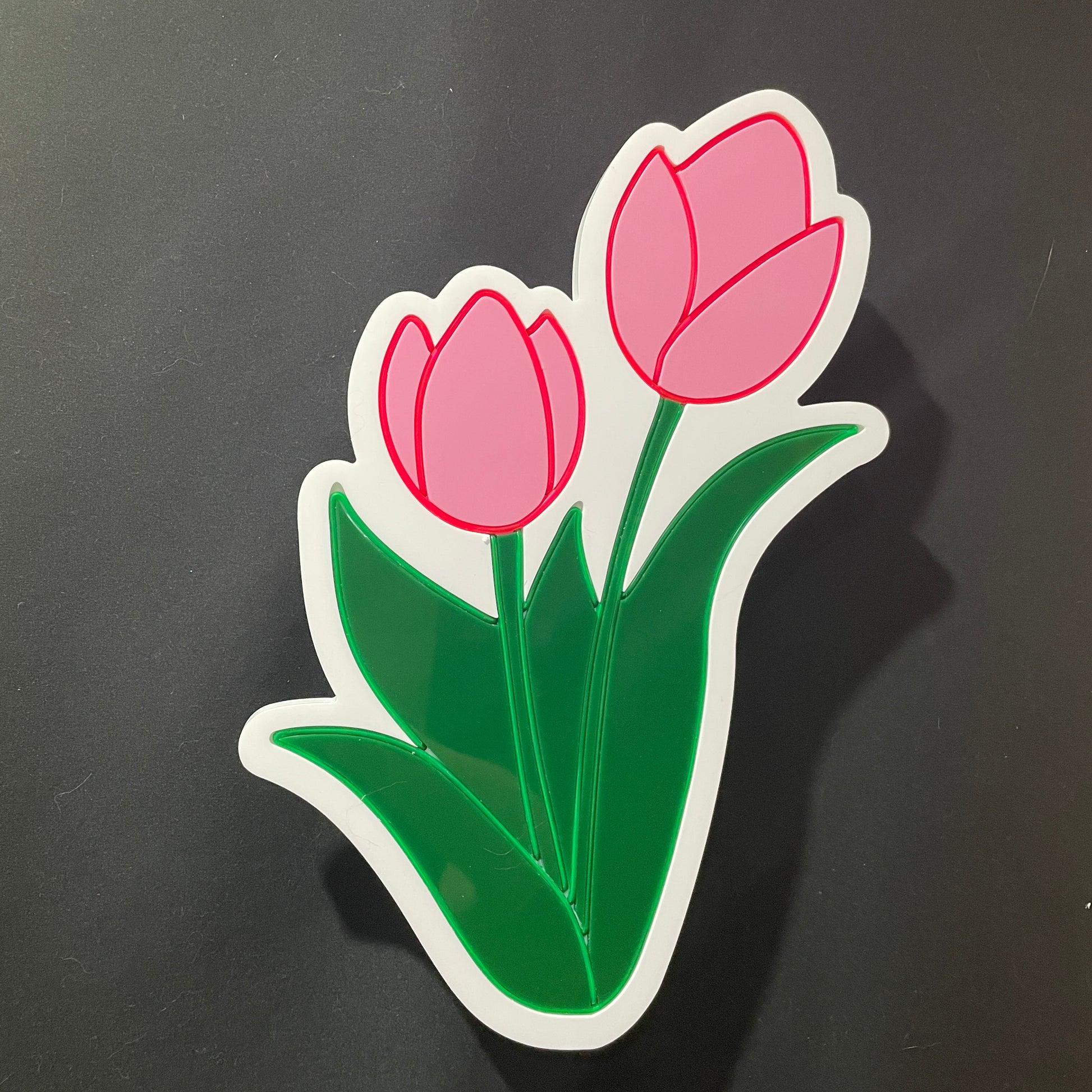 Two pink tulips with green leaves and stems neon light not lit up