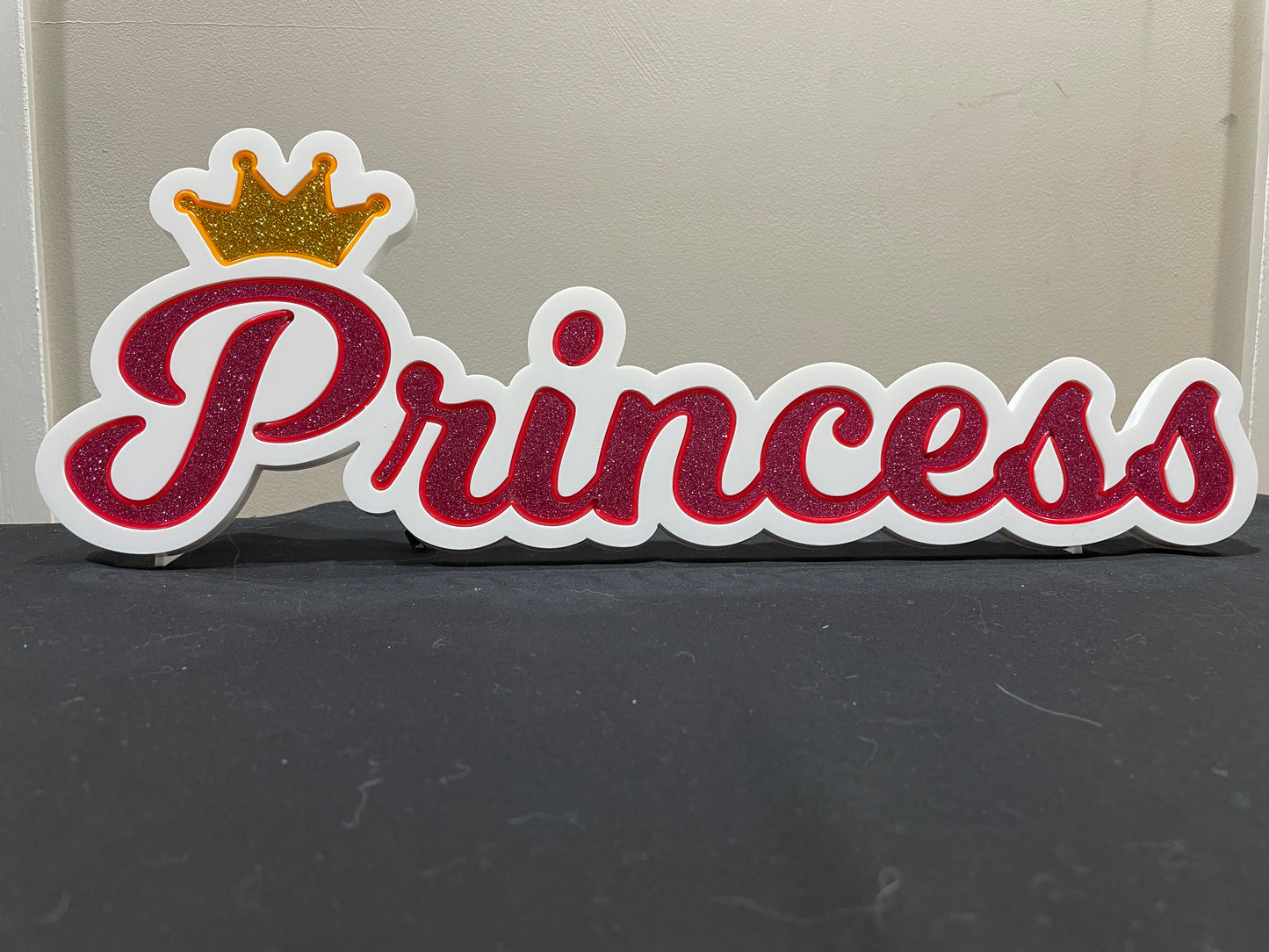 Princess neon name light in pink with a gold crown displayed not lit up