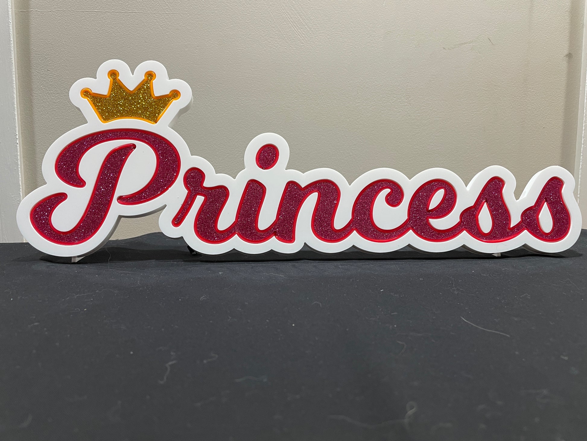 Princess neon name light in pink with a gold crown displayed not lit up