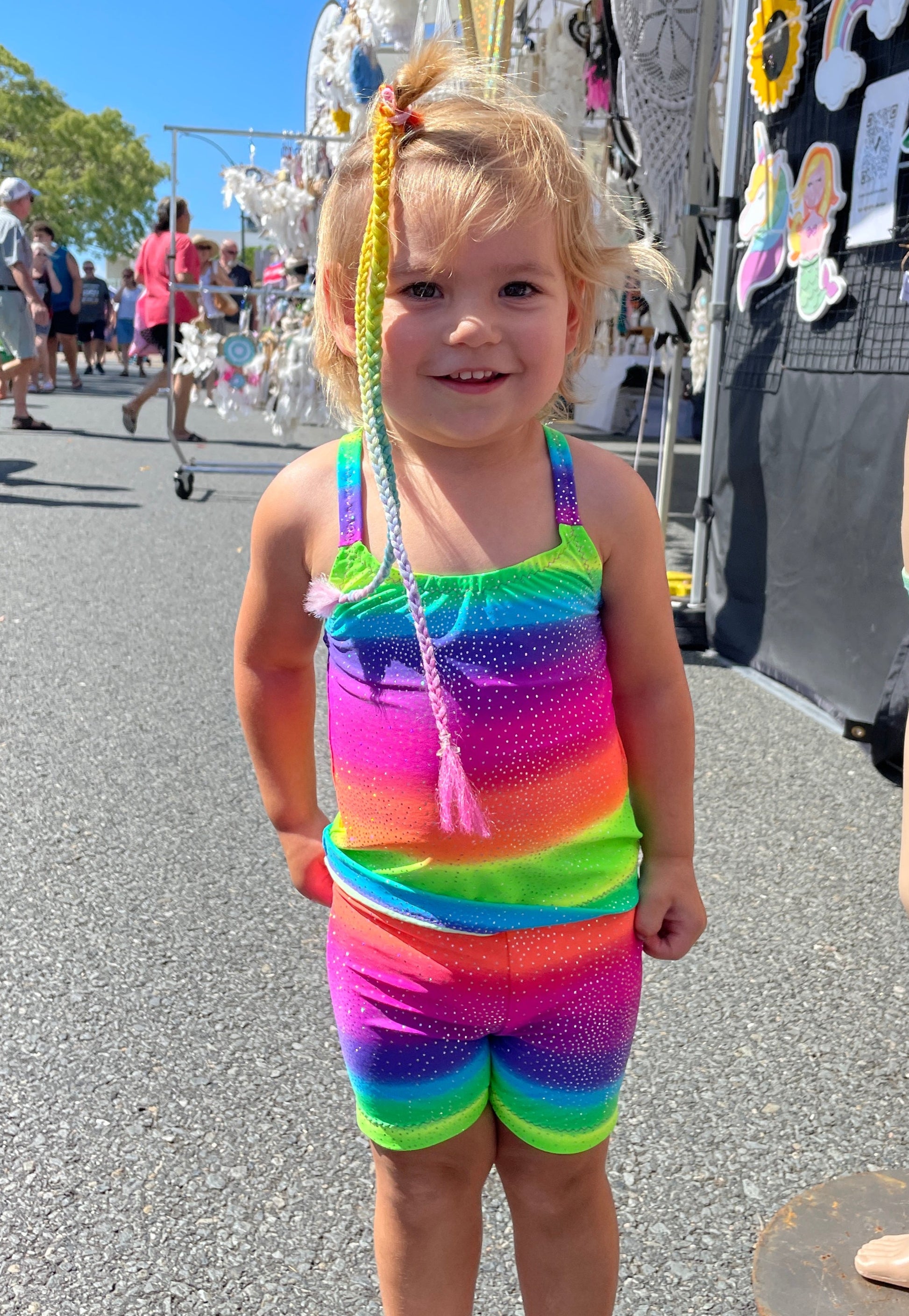 Toddler wearing a bright rainbow singlet top and matching shorts Brisbane Australia