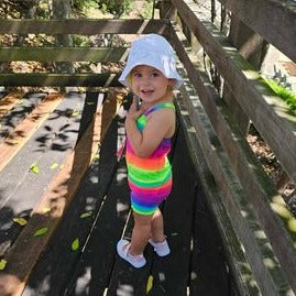 Toddler wearing bright rainbow singlet cop and shorts (2) Brisbane Australia