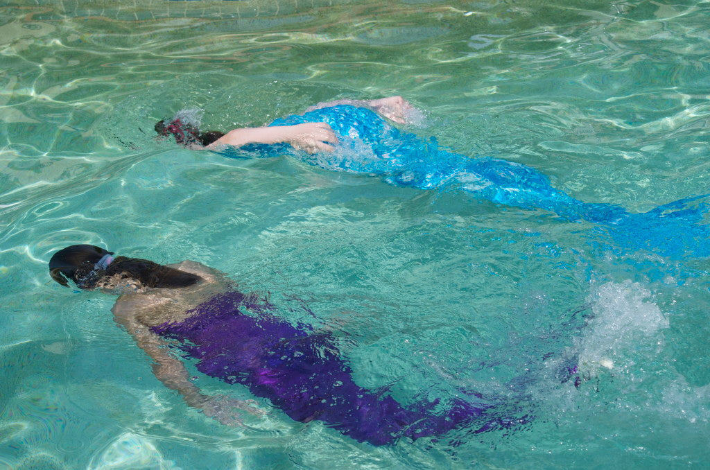 Two girls swimming as mermaids wearing swimmable mermaid tails Brisbane Australia
